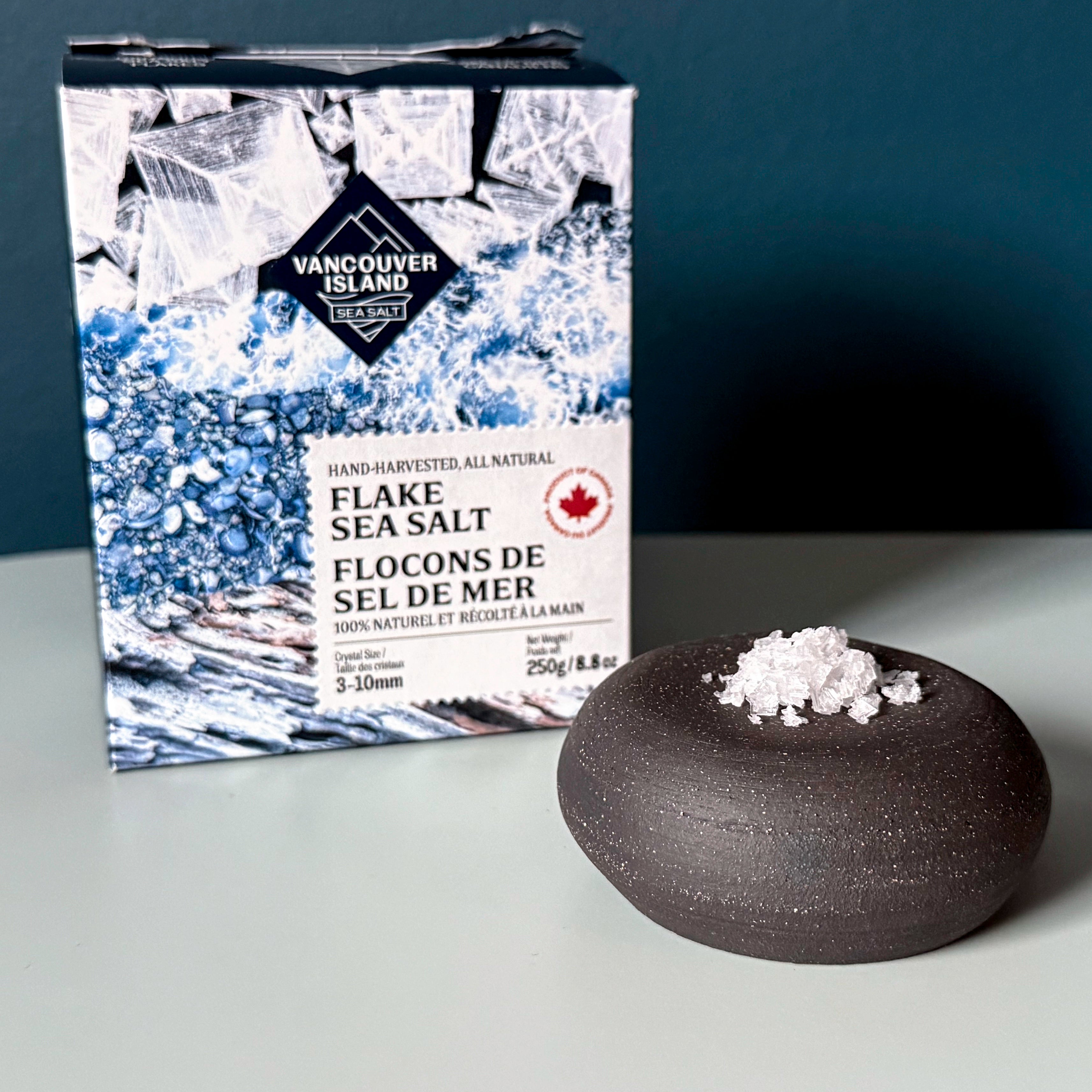Vancouver Island Flake Sea Salt packaging with a small bowl of salt on a gray background