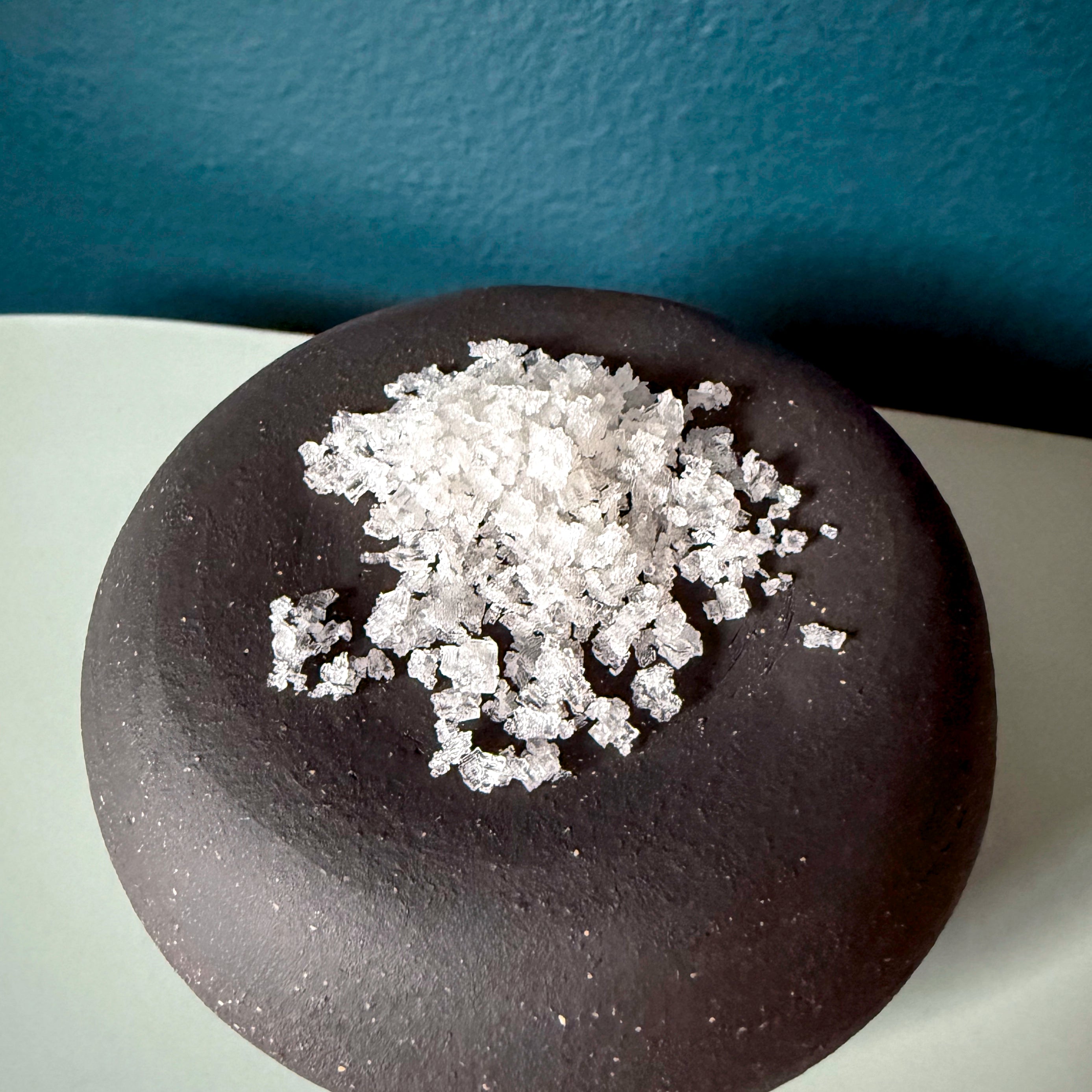flake salt close up on a black tray